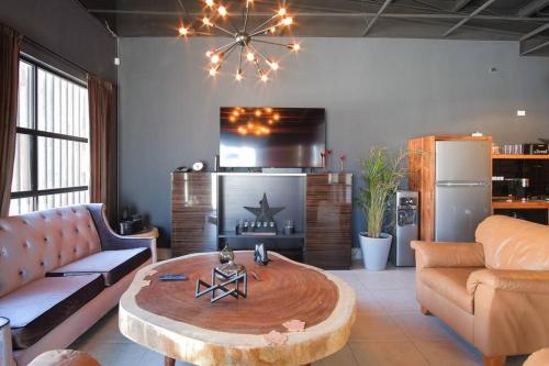 a living room with a couch and a coffee table at Brand New Gorgeous Industrial Loft in Downtown Ens in Ensenada