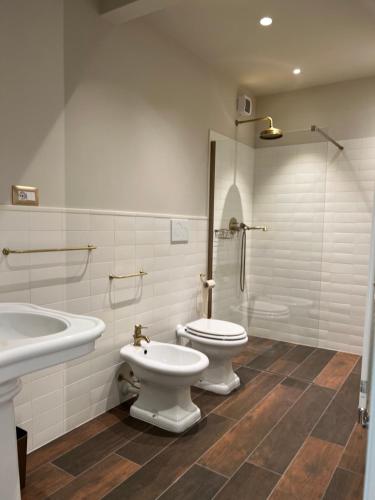 bagno con 2 servizi igienici, lavandino e doccia di Le Finestre Sul Lago a Cesenatico