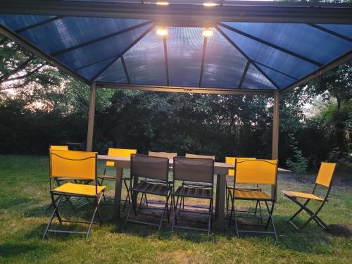 a table and chairs under a blue canopy at Chambres d'Hôtes Troglodytes Le Clos de L'Hermitage in Amboise