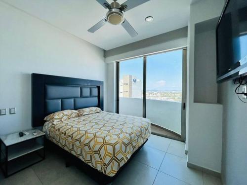 une chambre avec un lit et une grande fenêtre dans l'établissement A pie de playa con hermosas vistas by G P S rentas, à Mazatlán