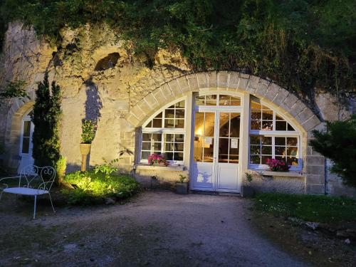 - un bâtiment avec une porte blanche et une fenêtre dans l'établissement Chambres d'Hôtes Troglodytes Le Clos de L'Hermitage, à Amboise