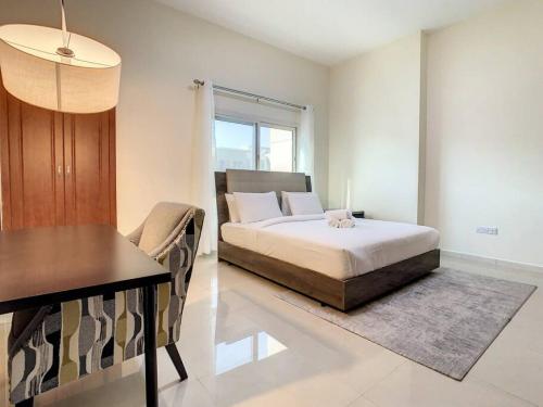 a bedroom with a bed and a dining table at Key View - Silicon Star in Dubai