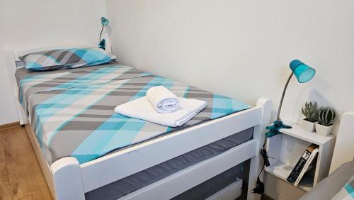 a small bedroom with a bed with a blue and grey comforter at Holiday Home Natura with private pool in Mostar