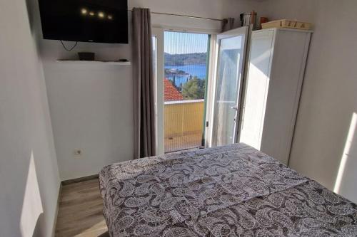 ein Schlafzimmer mit einem Bett und einem großen Fenster in der Unterkunft Apartments Belvedere - A4 in Nečujam