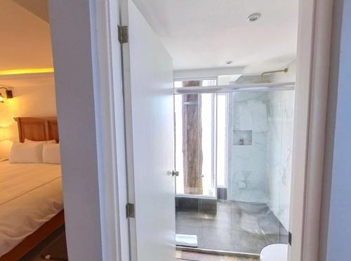 a room with a bed and a window and a bathroom at Hacienda Valentino in San Cristóbal de Las Casas