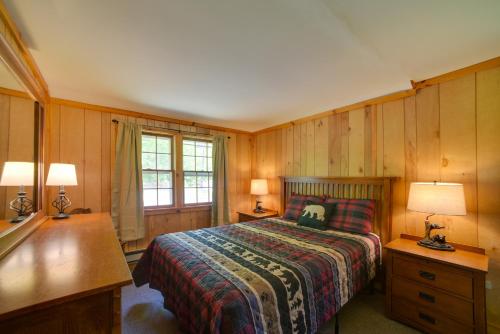 a bedroom with a bed and a desk and two lamps at Lakefront Adirondack Getaway with Beach and Kayaks! in Lake Pleasant