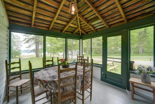 a dining room with a table and chairs and windows at Lakefront Adirondack Getaway with Beach and Kayaks! in Lake Pleasant