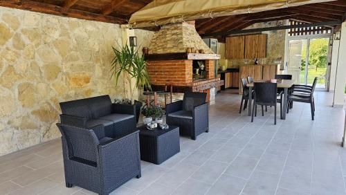 a patio with chairs and a table and a fireplace at Holiday Home Natura with private pool in Mostar