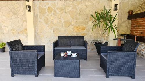 a patio with two chairs and a table with cups on it at Holiday Home Natura with private pool in Mostar