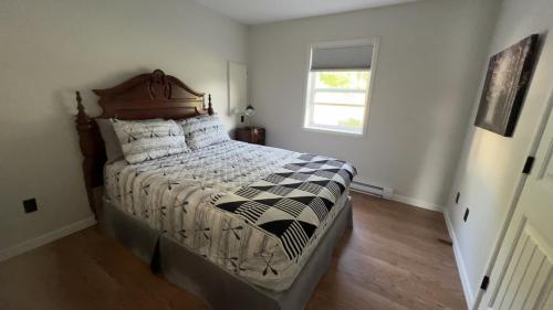 a bedroom with a bed with a black and white comforter at Douglas Lake Paradise A in Saint John