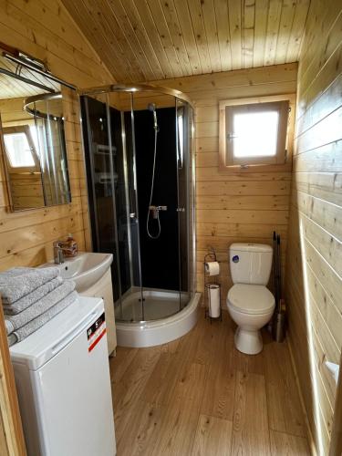 een badkamer met een bad, een toilet en een douche bij Domki Me Mazury in Giżycko