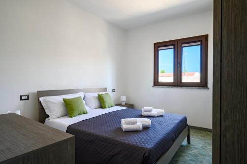 洛特佐拉伊的住宿－5 - Relax e comfort in casa con giardino - Sa Crai Apartments Sardinian Experience，一间卧室配有带毛巾的床