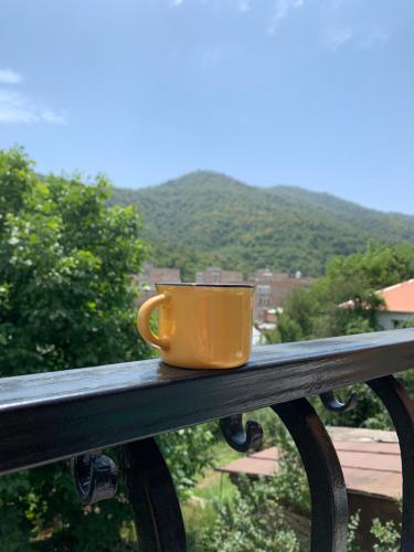 a yellow coffee cup sitting on a rail at Mountain View Guesthouse in Dilijan