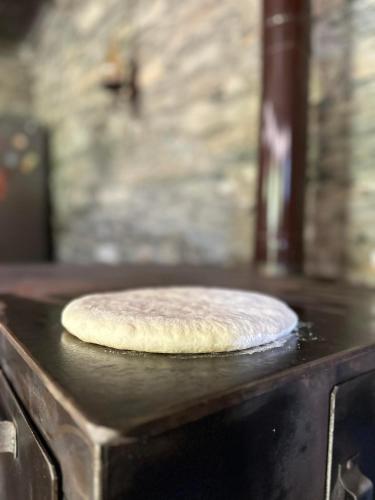 a uncooked pizza sitting on top of an oven at Guesthouse Divo Hut in Ushguli