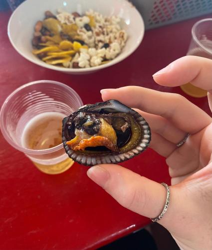 a person holding a oyster on a table with a bowl of food at Linda Suite Tonsupa 2 cuadras del mar 2 piscinas Av. Club del Pacifico in Tonsupa