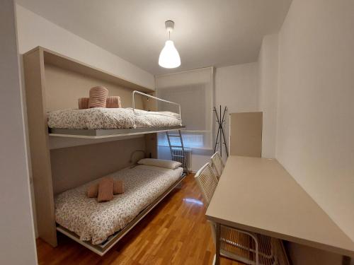 Home Sweet Home Pamplona Hospitales-Universidad في Barañáin: غرفة بسريرين بطابقين وطاولة