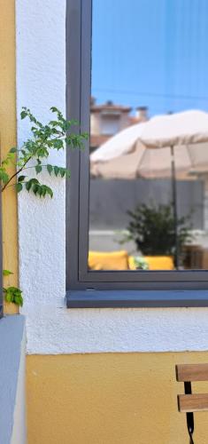 a window of a building with a table and an umbrella at Boavista Luxury Villas in Porto