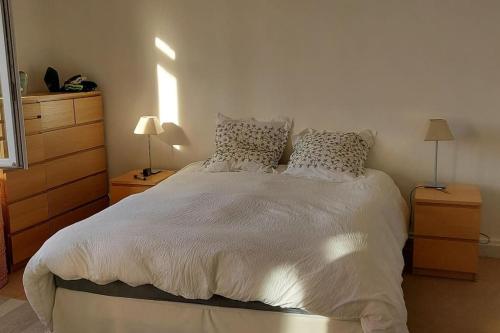 une chambre avec un grand lit blanc avec des oreillers dans l'établissement Hâvre de paix dans un écrin de verdure, à Avignon