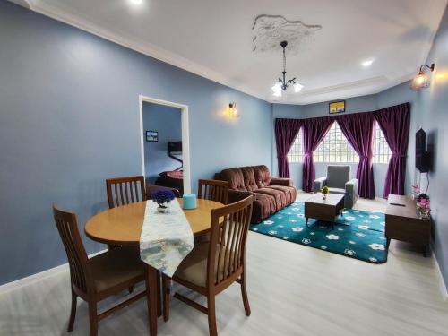 - un salon avec une table et un canapé dans l'établissement A One Holiday Apartment - PRO, à Tanah Rata