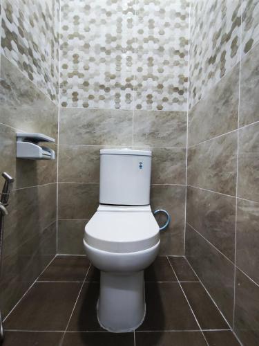 a bathroom with a white toilet in a room at A One Holiday Apartment - PRO in Tanah Rata