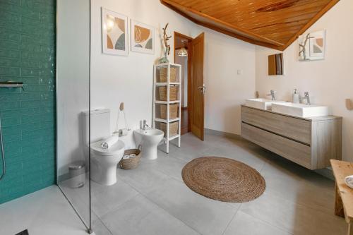 een badkamer met 2 toiletten, een wastafel en een douche bij Alma Country House in Carvalhal