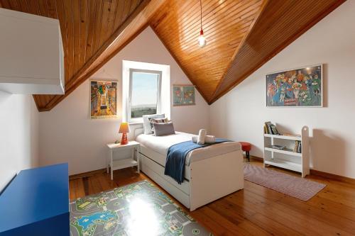 een slaapkamer met een bed en een houten plafond bij Alma Country House in Carvalhal