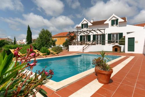 a swimming pool in front of a house at Alma Country House in Carvalhal