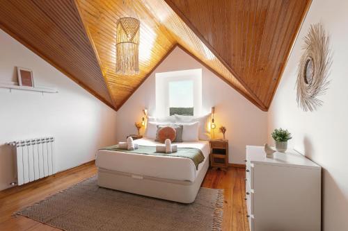 a bedroom with a bed and a wooden ceiling at Alma Country House in Carvalhal