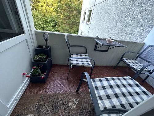 a balcony with chairs and a table and a table at Moderne und komfortable Appartements im Ferienpark Hahnenklee in Hahnenklee-Bockswiese