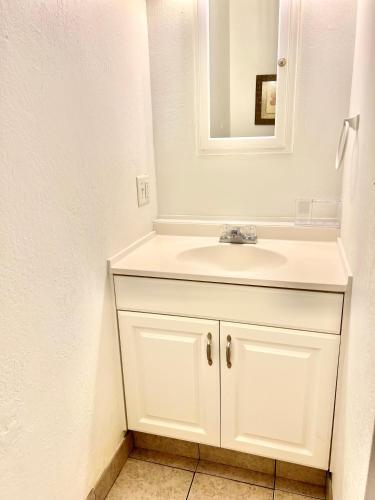 a bathroom with a white sink and a mirror at MAILAN HALE II in Kailua-Kona