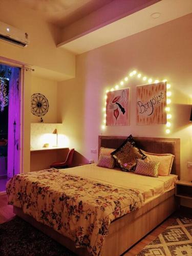 a bedroom with a bed with lights on the wall at Paris Suite By Hey Studio's in Ghaziabad