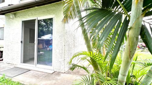 a white house with a sliding glass door at MAILAN HALE II in Kailua-Kona