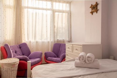 Habitación con 2 sillas y 1 cama con toallas en Flat with Large Balcony in Izmir, en Izmir