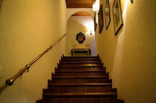 a staircase in a building with a clock on the wall at ColmarinoHouse in Rotorscio