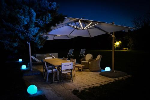 a table and chairs under an umbrella at night at ColmarinoHouse in Rotorscio