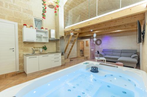 een groot blauw bad in een kamer met een bank bij Suite16 & spa in Barletta
