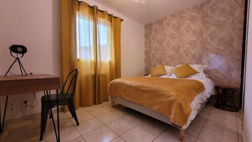 a bedroom with a bed and a desk and a window at Entre Ciel et Verdon in Castellane