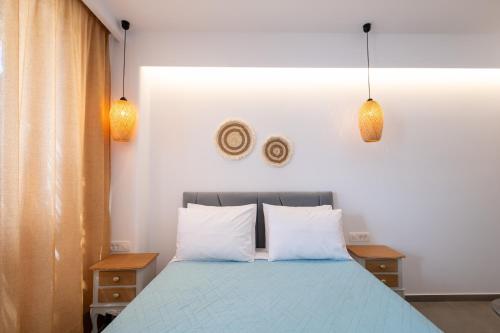 a bedroom with a blue bed with two pillows at Sand Gem - Beach Apartments in Perivolos