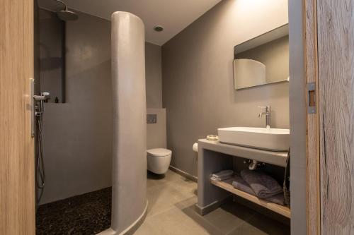 a bathroom with a sink and a toilet at Sand Gem - Beach Apartments in Perivolos