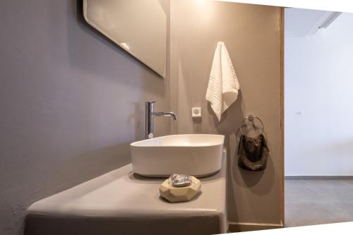 a bathroom with a sink and a mirror at Sand Gem - Beach Apartments in Perivolos