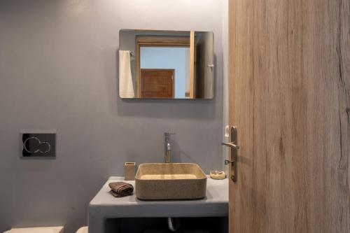 a bathroom with a sink and a mirror at Sand Gem - Beach Apartments in Perivolos