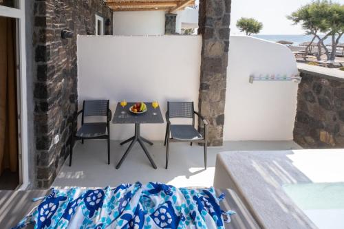 a small balcony with a table and chairs at Sand Gem - Beach Apartments in Perivolos