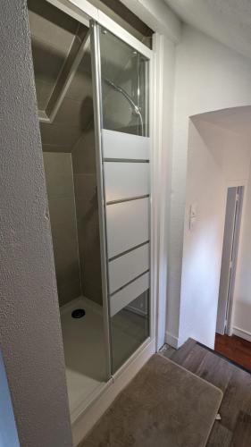 un placard en verre avec une porte en verre dans la chambre dans l'établissement L'Entracte - Appart Hôtel - Hypercentre, à La Ferté-Alais