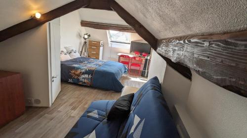 um pequeno quarto com uma cama e um quarto em L'Entracte - Appart Hôtel - Hypercentre em La Ferté-Alais