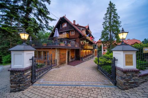 a house with a gate in front of it at Hotel Modrzewiówka in Lanckorona