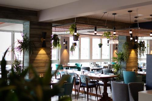 a dining room with tables and chairs and windows at Rooms at The Deck, Penarth in Cardiff