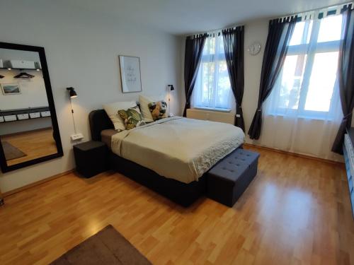 1 dormitorio con cama y espejo grande en Wohlfühl-Wohnung im Herzen der Stadt Magdeburg, en Magdeburgo