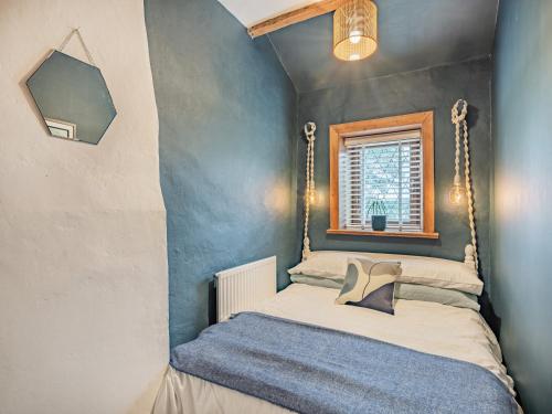 een kleine slaapkamer met een bed met een spiegel bij Weavers Cottage in Barrowford