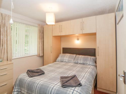 a bedroom with a bed with two towels on it at Sycamores in Liskeard