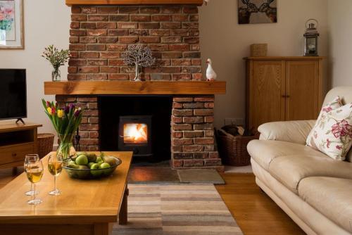 a living room with a fireplace with a bowl of fruit on a table at East Lodge, Yorkshire in Bedale